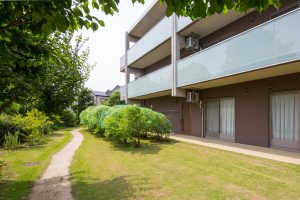 緑に囲まれた介護施設の建物外観。庭園から見た3階建ての施設全体