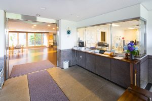 受付カウンターと広がりのあるロビー空間。明るく開放的な施設の玄関エリア