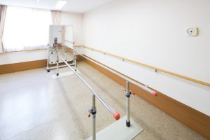 木製の手すりが備えられた広々とした機能訓練室。リハビリ設備が整備されている。